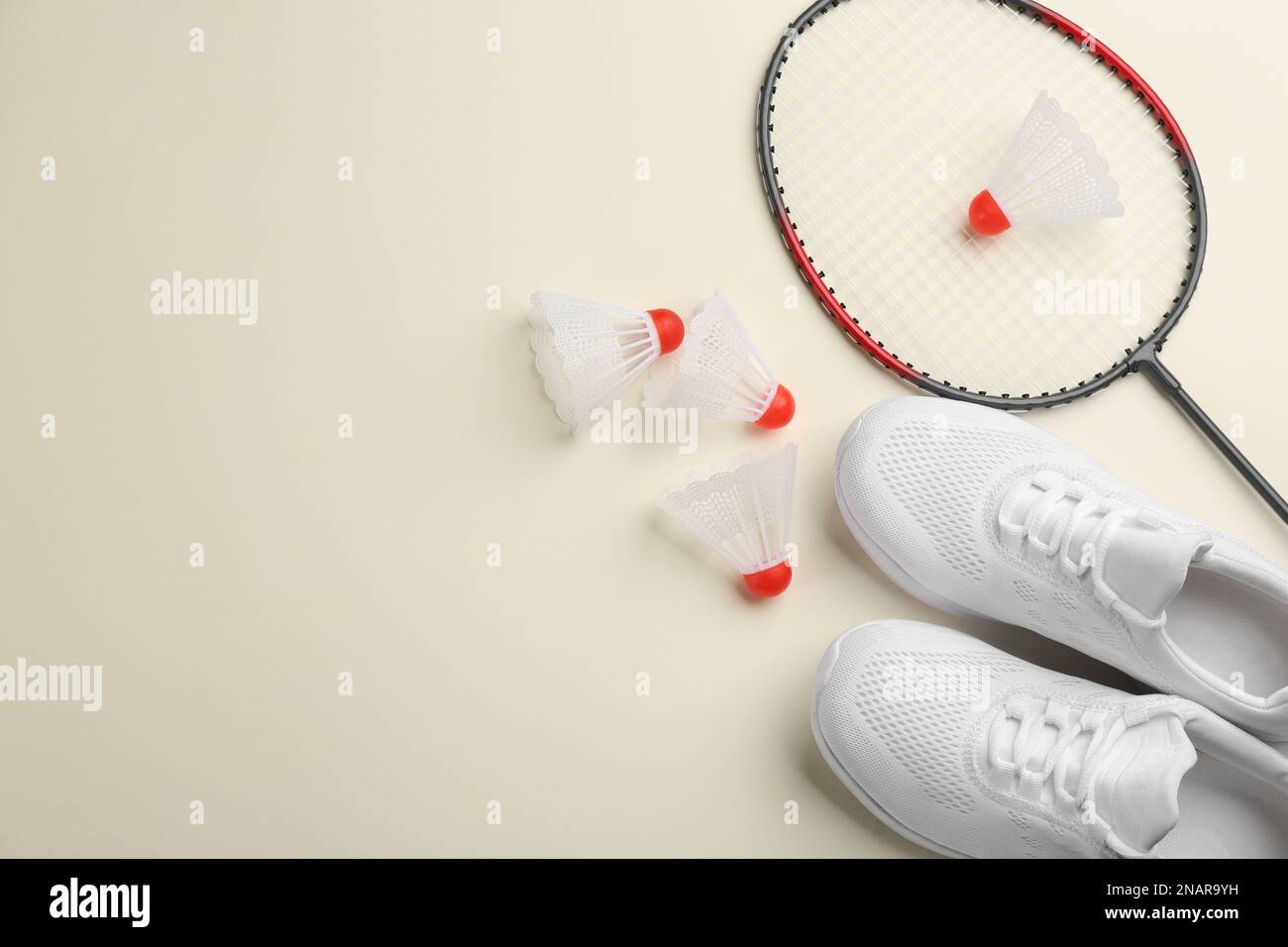 Badminton racket, shuttlecocks and shoes on light background, flat lay ...