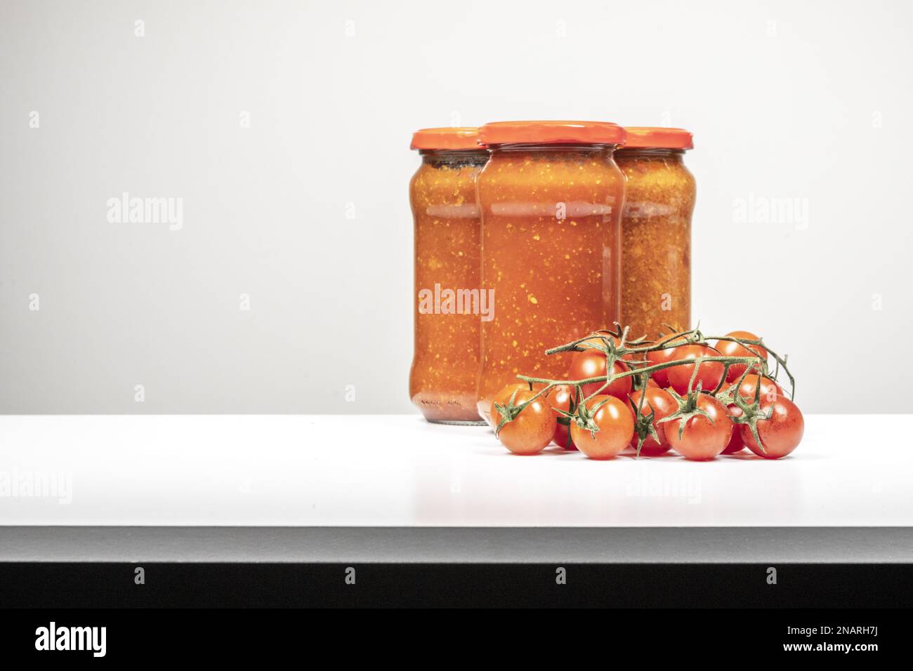 Still life with glass jars of canned red tomato sauce for pasta with a