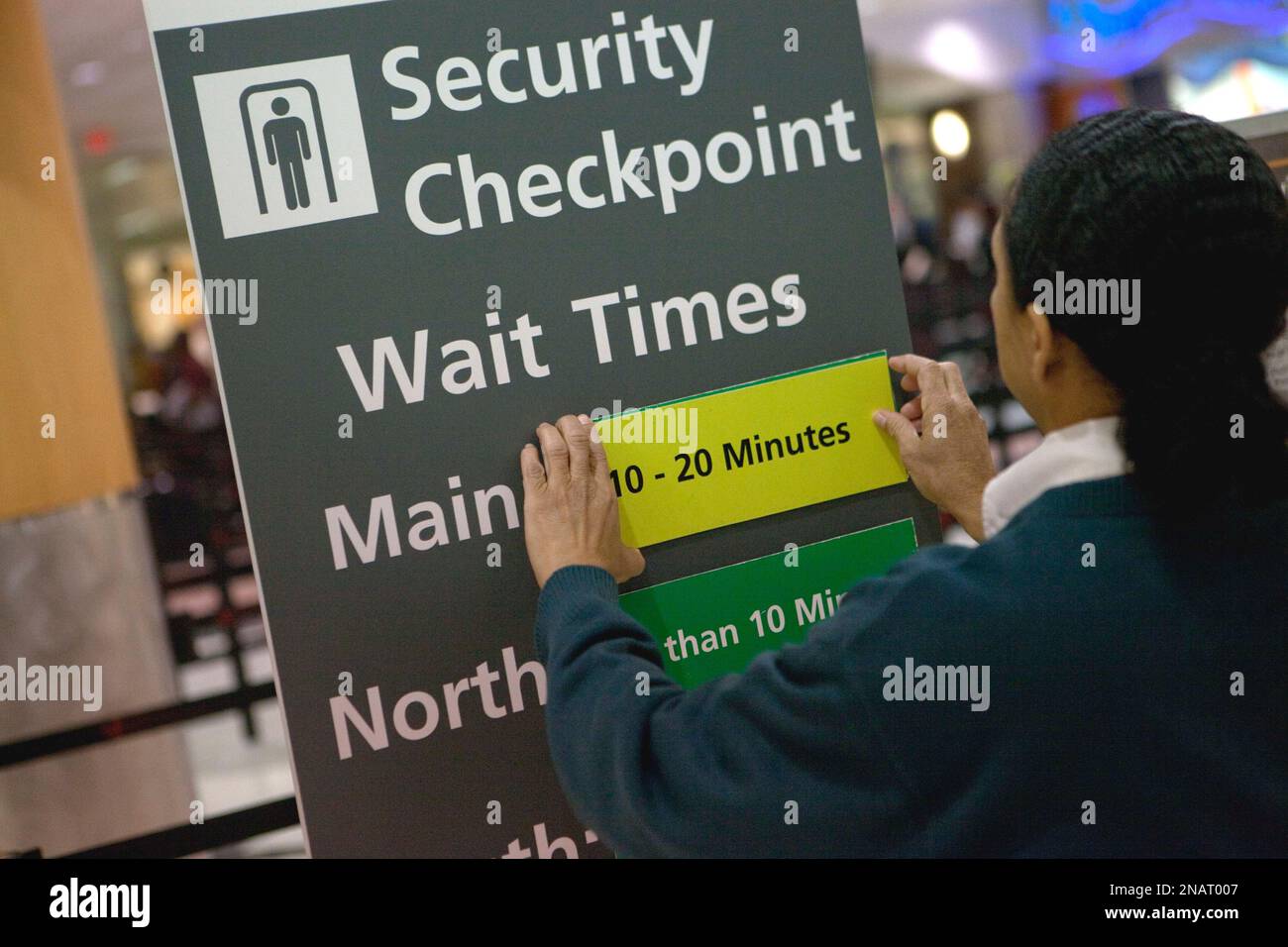 Customer service representative Paulette Laman adjusts a sign showing