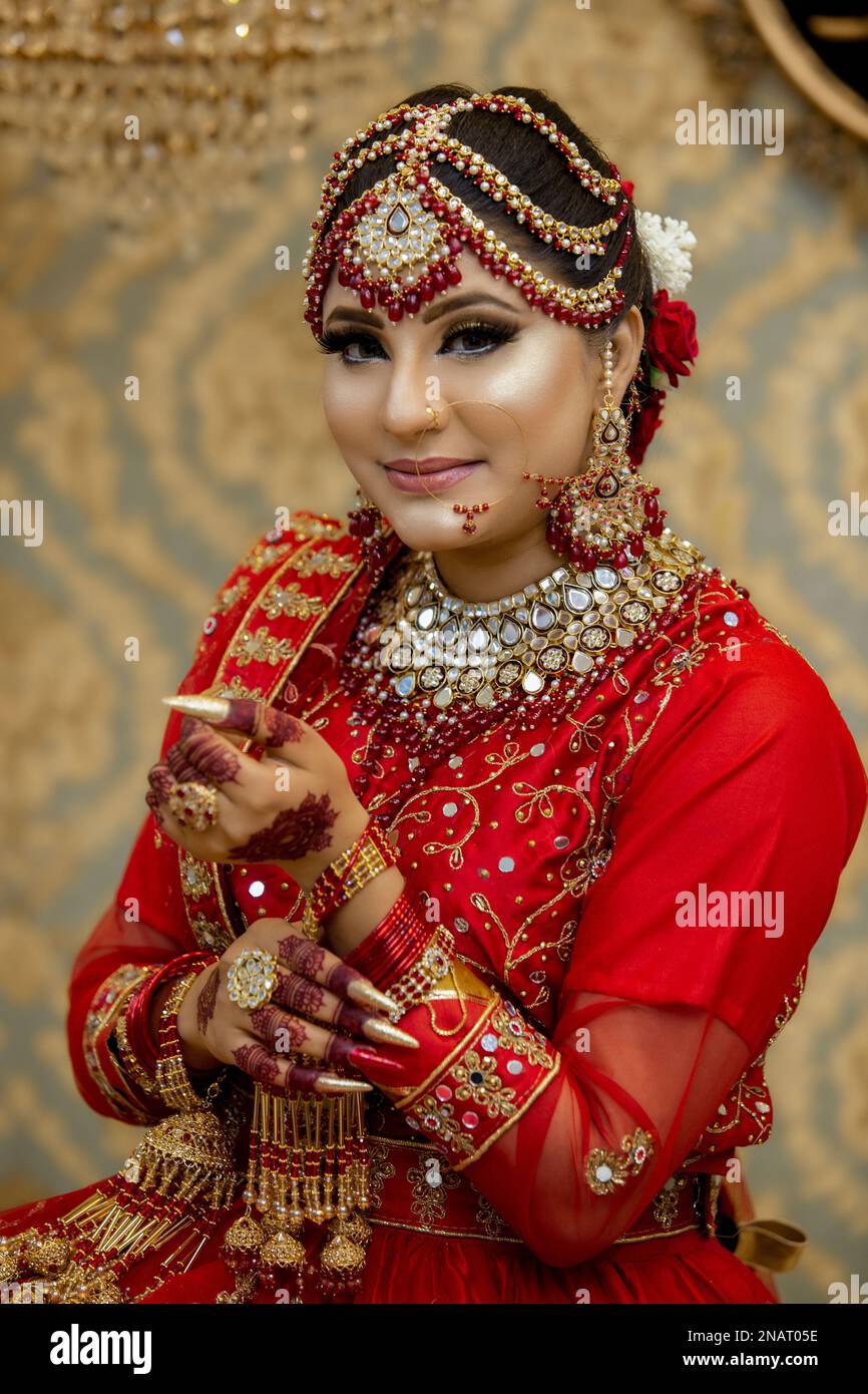 Indian and Pakistani bride dressed in traditional wedding clothes Stock Photo