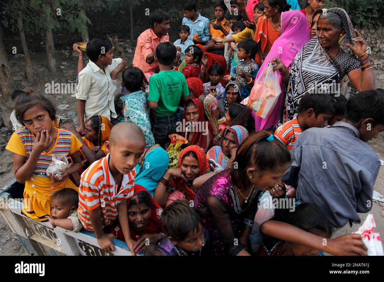 Pilgrims crowd a tractor trolley to return to their villages after ...