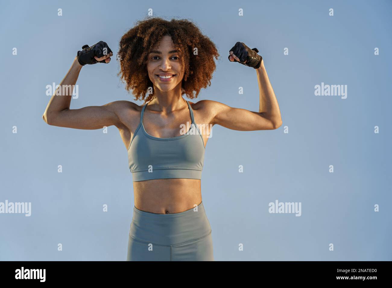 Young African American woman flexing biceps isolated over black background  Stock Photo - Alamy