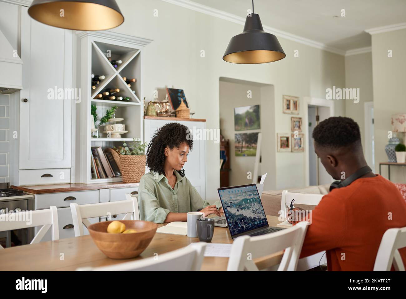 Multiracial couple working online from home using laptops Stock Photo