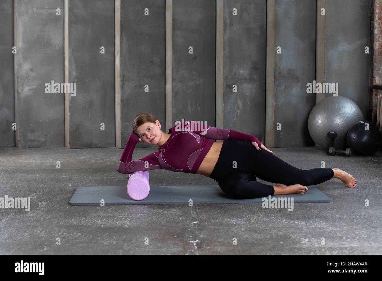A fitness instructor demonstrates myofascial release using a roller to