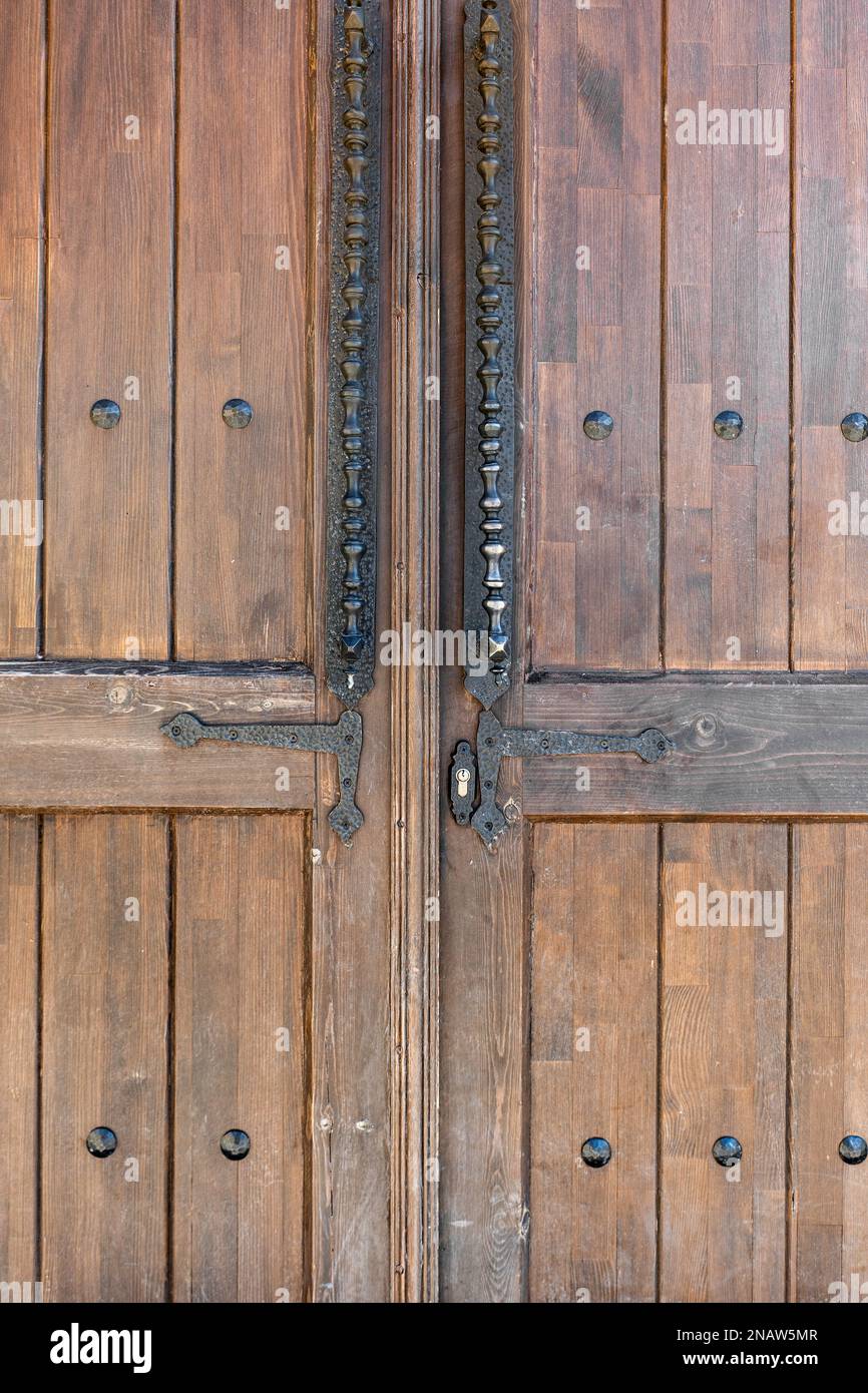 Old, faded classical, brown, wooden door with iron door handle. Door