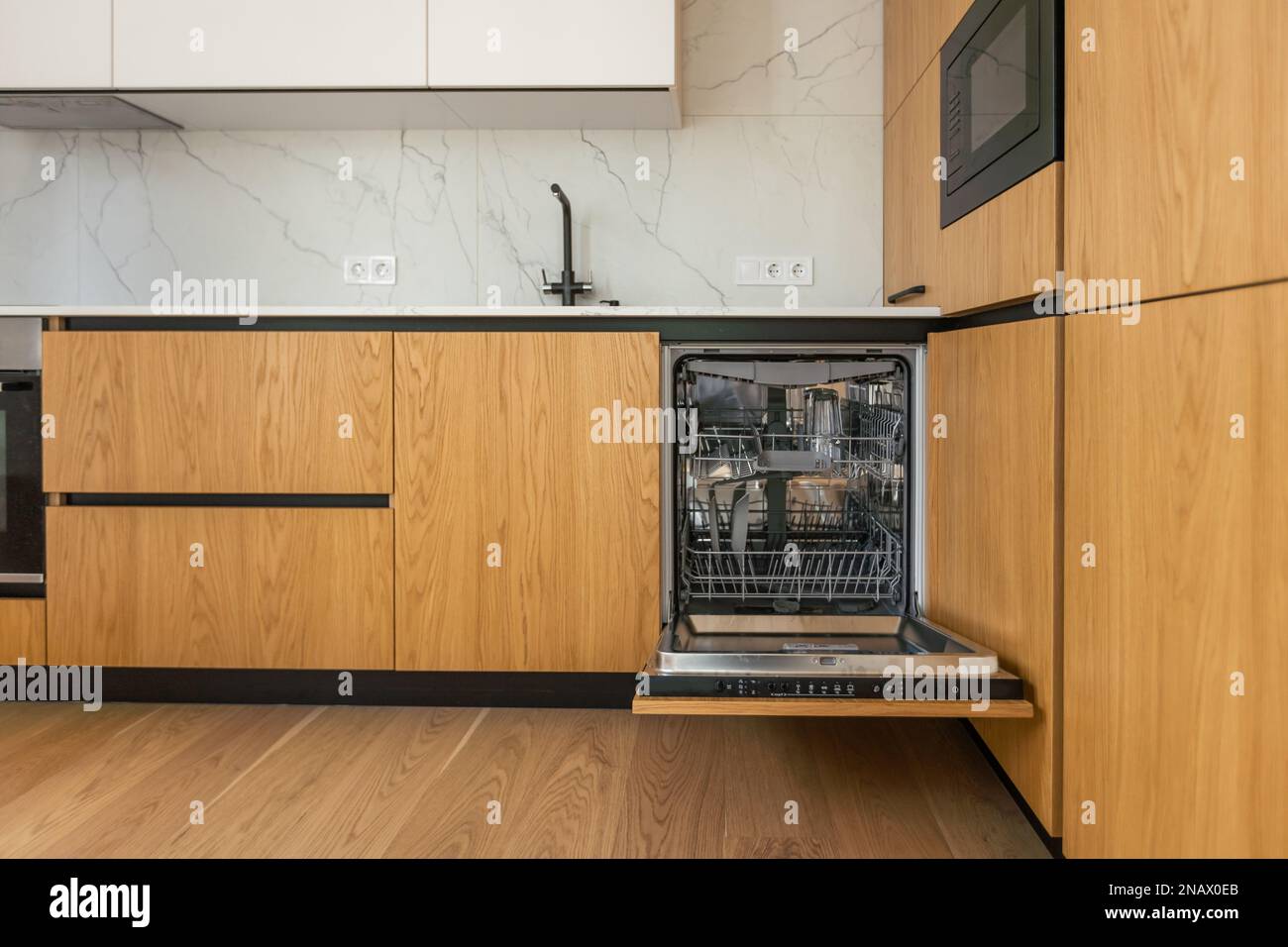 Modern kitchen with empty Builtin dishwasher with opened door