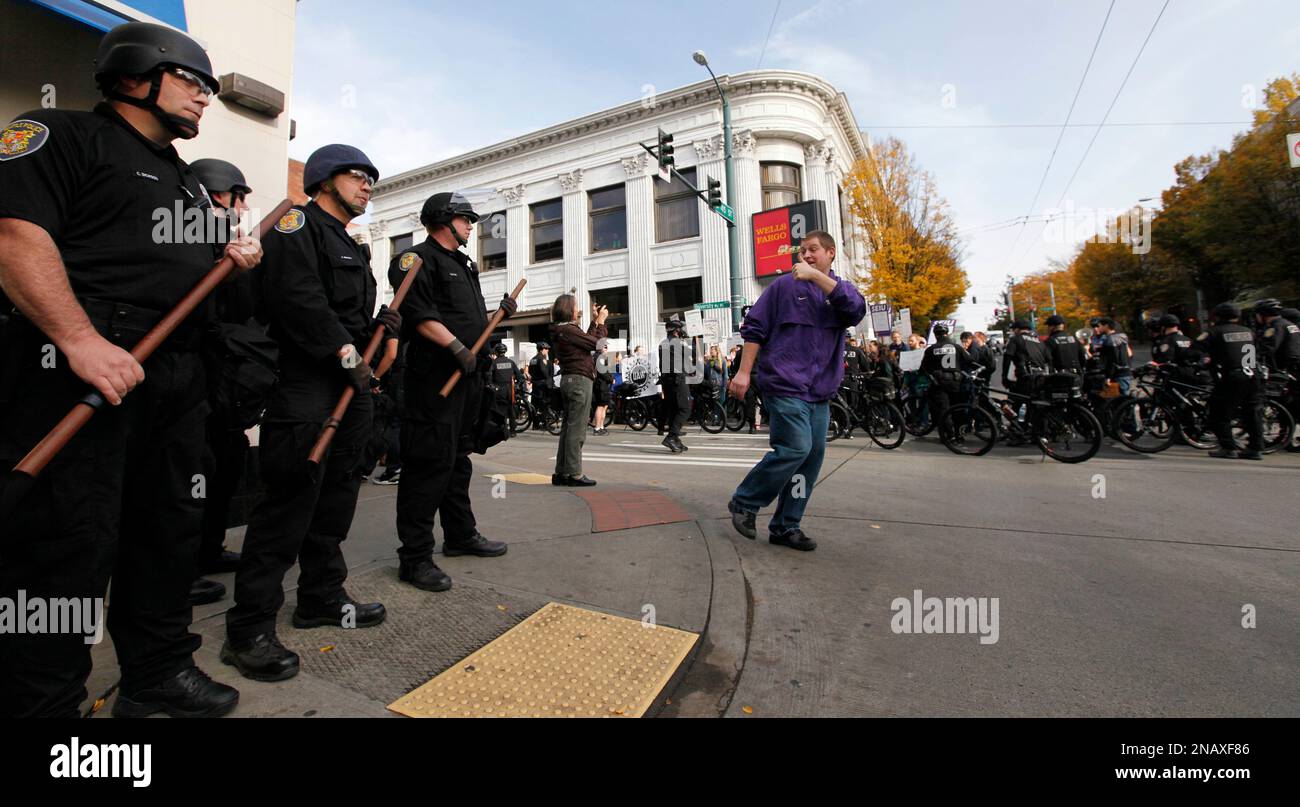 Seattle police officers wearing riot gear are given a thumbs-up sign by ...