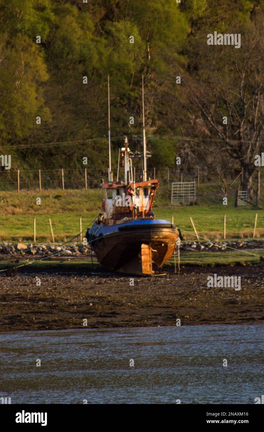 Fishing Boat on the shores of Loch Duich, Scotland at low tide Stock Photo