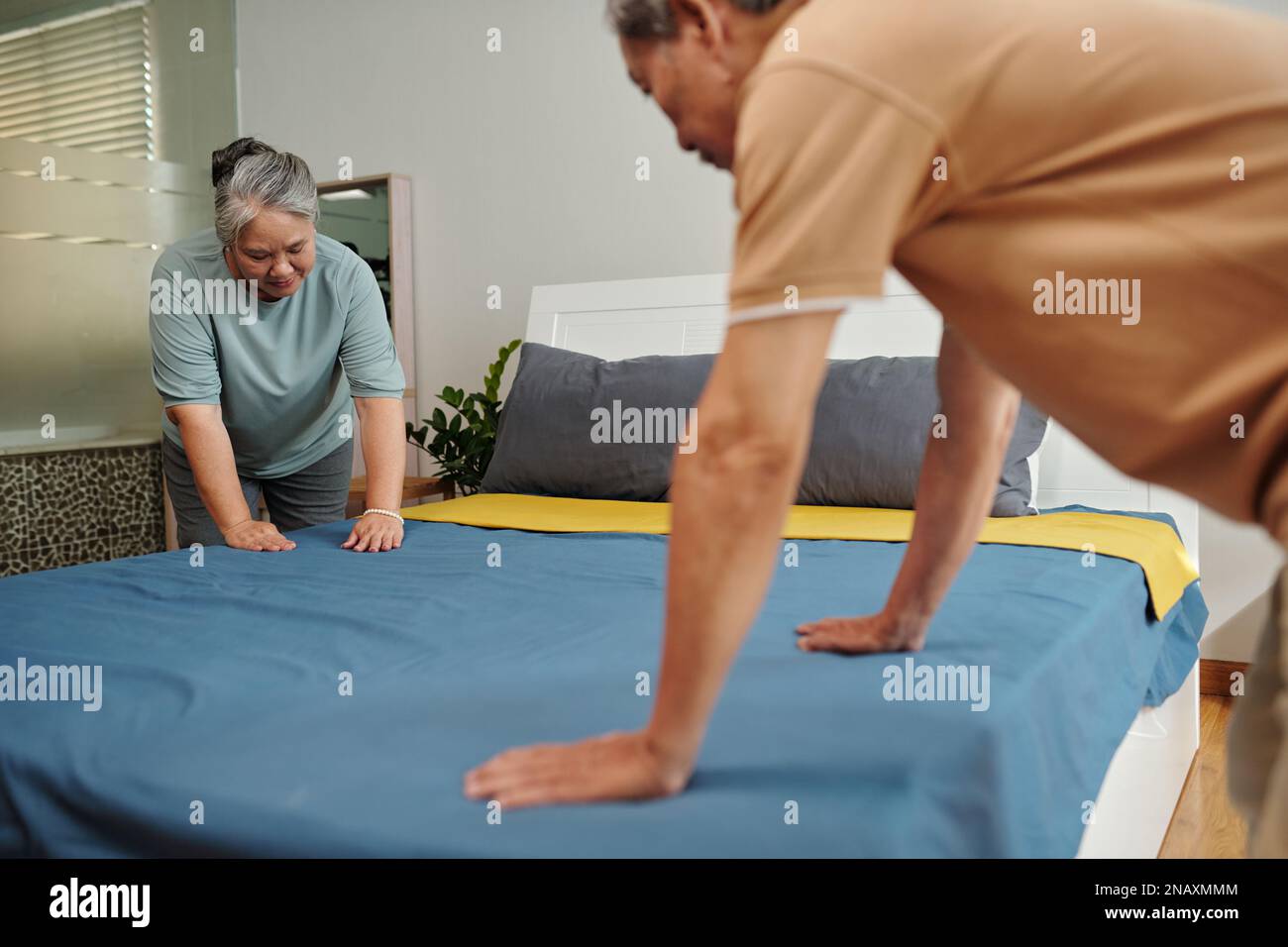 Senior couple changing sheets in guest bedroom Stock Photo Alamy