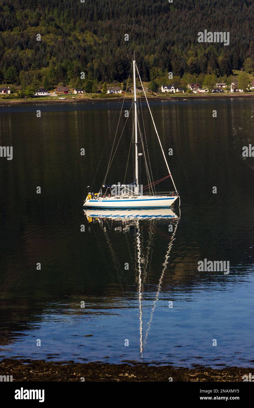 A singe sailboat, with its refection on on Loch Duich, in the Scottish Highlands Stock Photo
