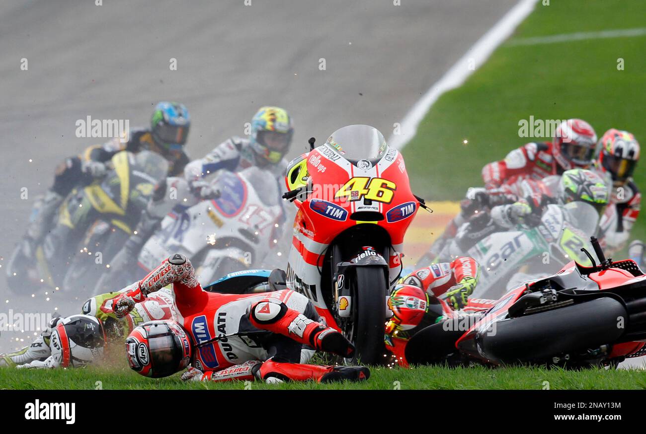 MotoGP Ducati rider Nicky Hayden from US, bottom left, falls on the first corner with MotoGP Valentino Rossi from Italy, bottom right, and MotoGP Randy de Puniet from France, bottom left, during