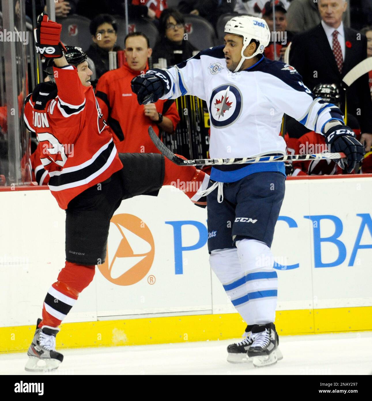 Winnipeg Jets' Dustin Byfuglien, right, checks New Jersey Devils' David