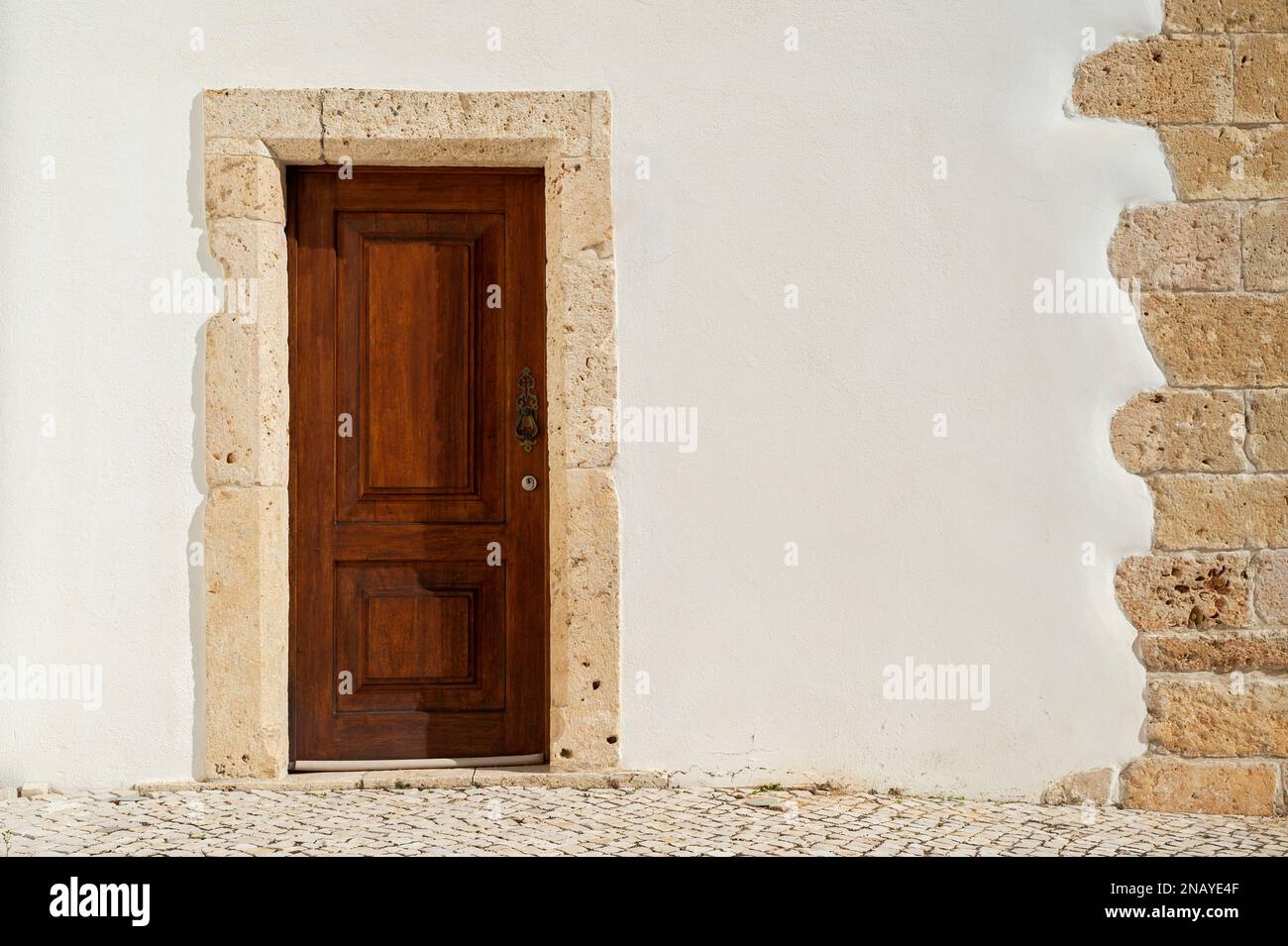 Wooden door in a white wall Stock Photo