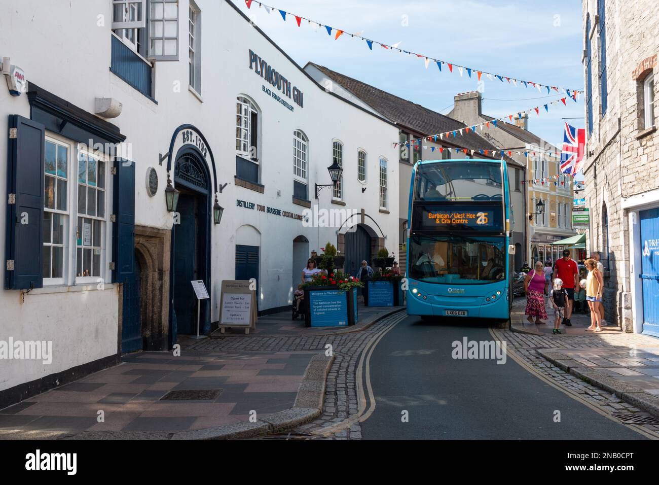The blue bus to the Barbican and West Hoe goes past the Plymouth Gin distillery on Southside Street in Plymouth, Devon, UK. Stock Photo