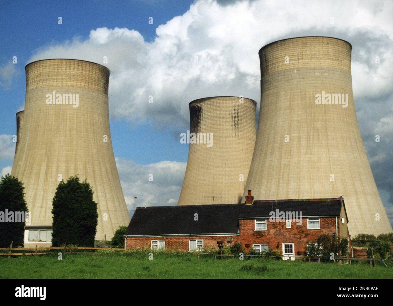 Mighty cooling towers dwarf a farmhouse at Ratcliffe-on-Soar in Nottinghamshire Stock Photo