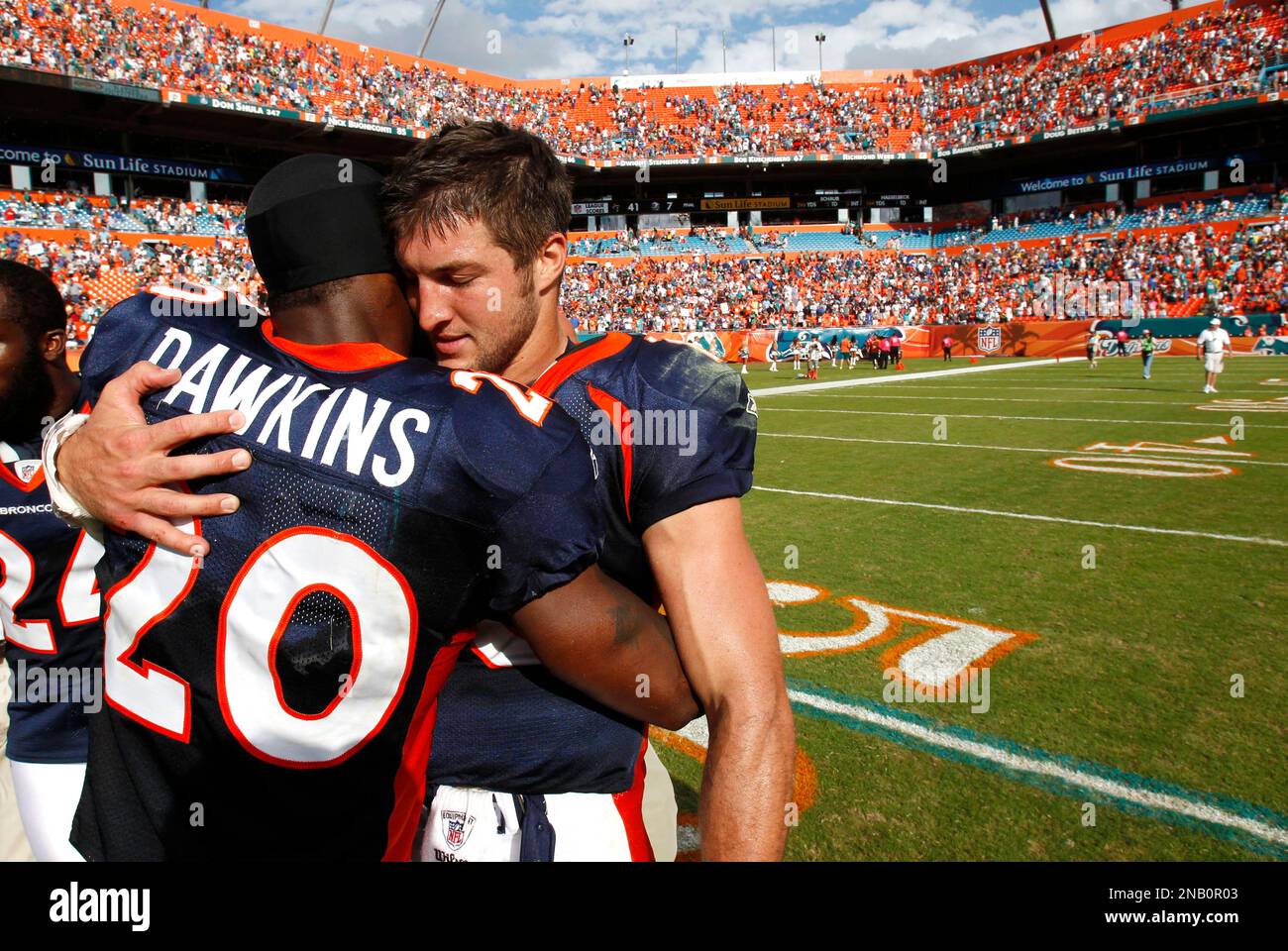 Denver Broncos quarterback Tim Tebow (15) and strong safety Brian Dawkins  (20) hug at the end