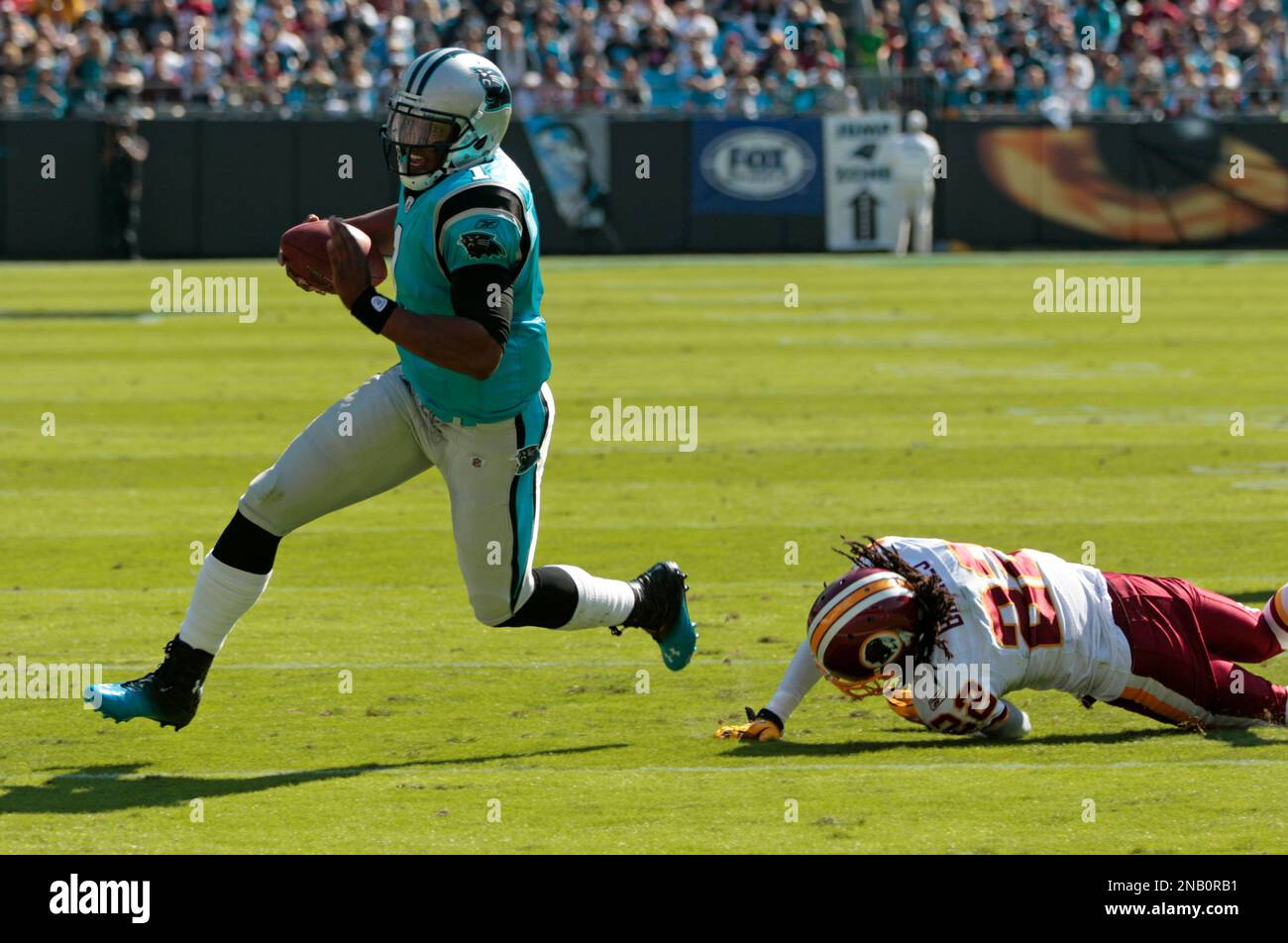 Carolina Panthers' Cam Newton (1) scrambles against the Washington Redskins'  Kevin Barnes (22) during the first quarter of an NFL football game in  Charlotte, N.C., Sunday, Oct. 23, 2011. (AP Photo/Chuck Burton