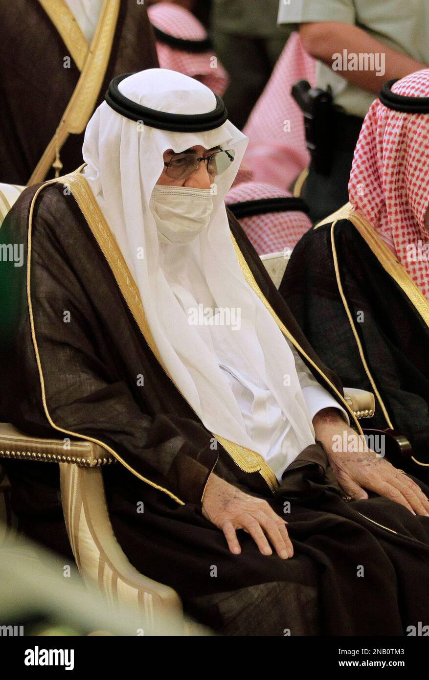 King Abdullah of Saudi Arabia, center, covers his face with a medical ...