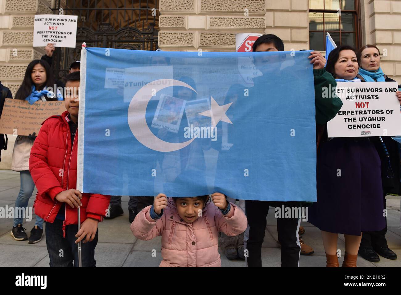 London, England, UK. 13th Feb, 2023. Children hold Uyghur flag outside the Foreign Office, during the protest. Uyghur and human rights activists gathered oposite Foreign, Commonwealth & Development Office in London to protest against Chinese delegation with Erkin Tuniyaz, the governor of Xinjiang region, where it is claimed genocide and crimes against human rights are occuring, allegedly meeting with senior British officials. (Credit Image: © Thomas Krych/ZUMA Press Wire) EDITORIAL USAGE ONLY! Not for Commercial USAGE! Stock Photo