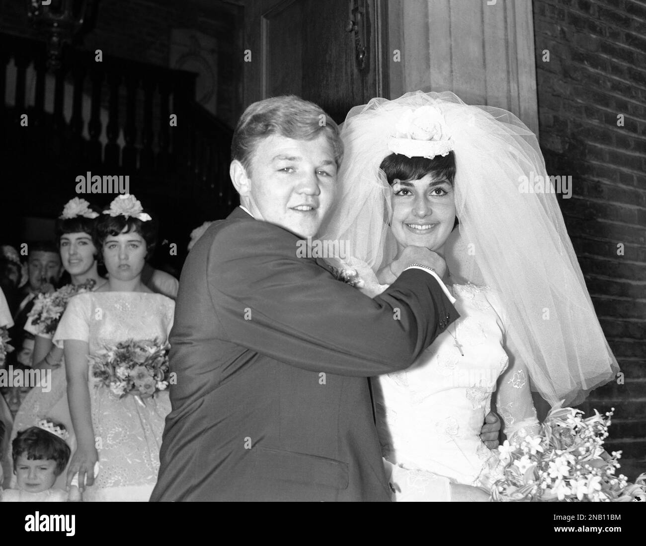 Former British Featherweight boxing champion Terry Spinks playfully chucks  his bride under the chin with the fist that won him his titles after their  wedding at St. James's, Piccadilly, London, on July, image size:1300x1100