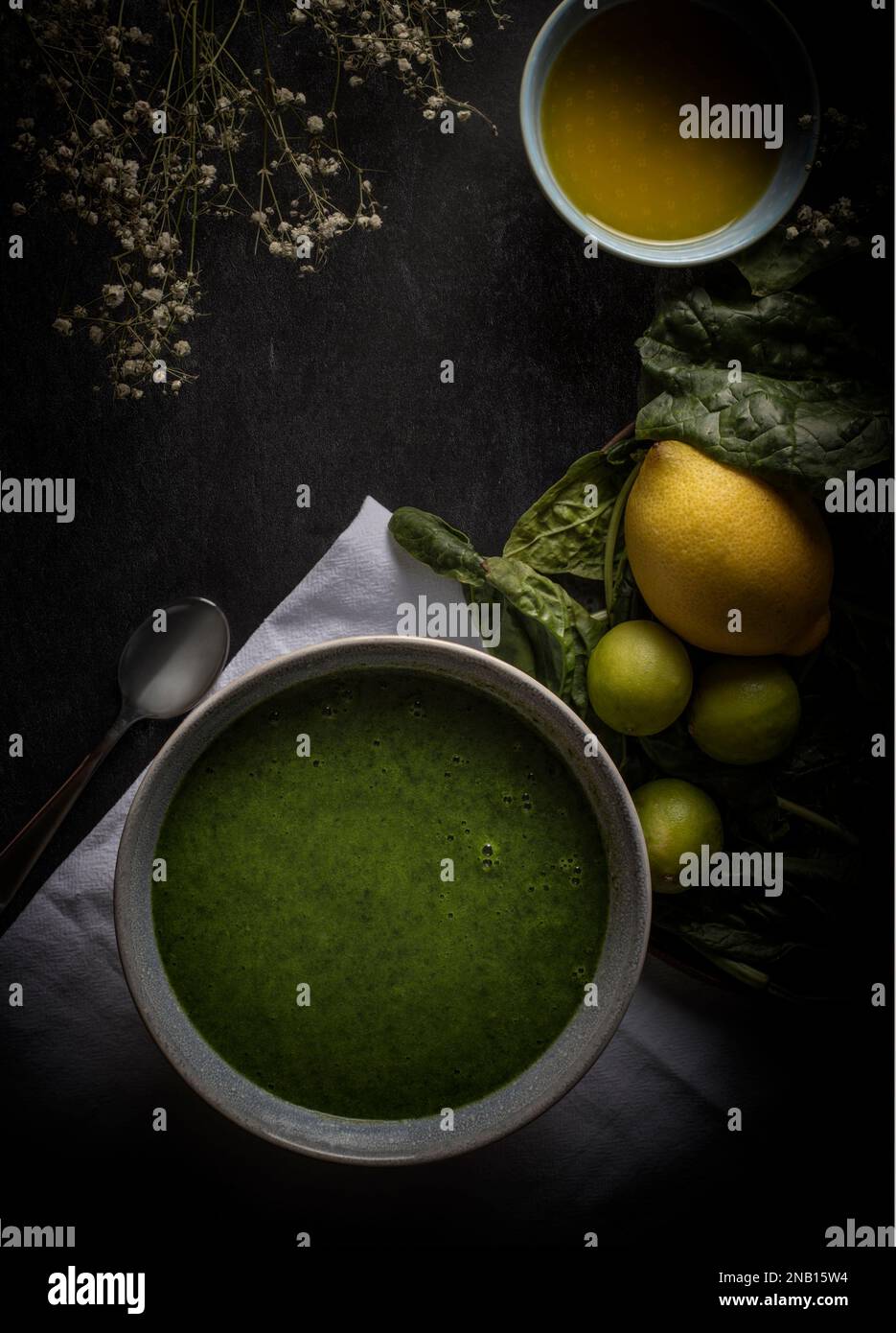 Spinach Cream with lemons, olive oil and spinach leaves. Photographed in a  Dark Mood aesthetic Stock Photo
