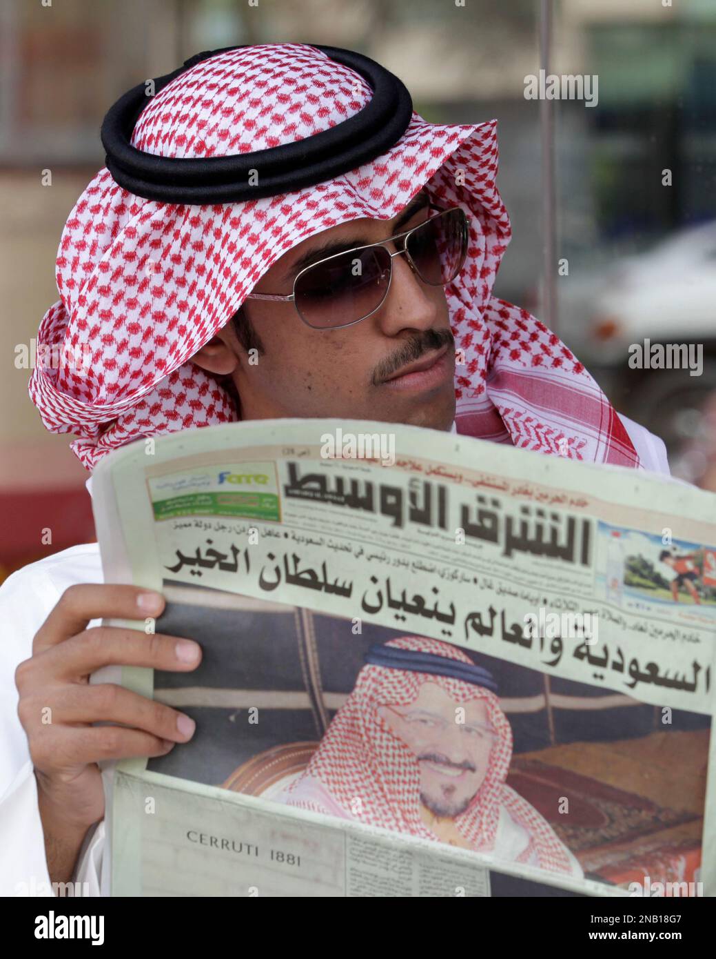 A saudi man reads al sharq al awsat newspaper displaying a picture of