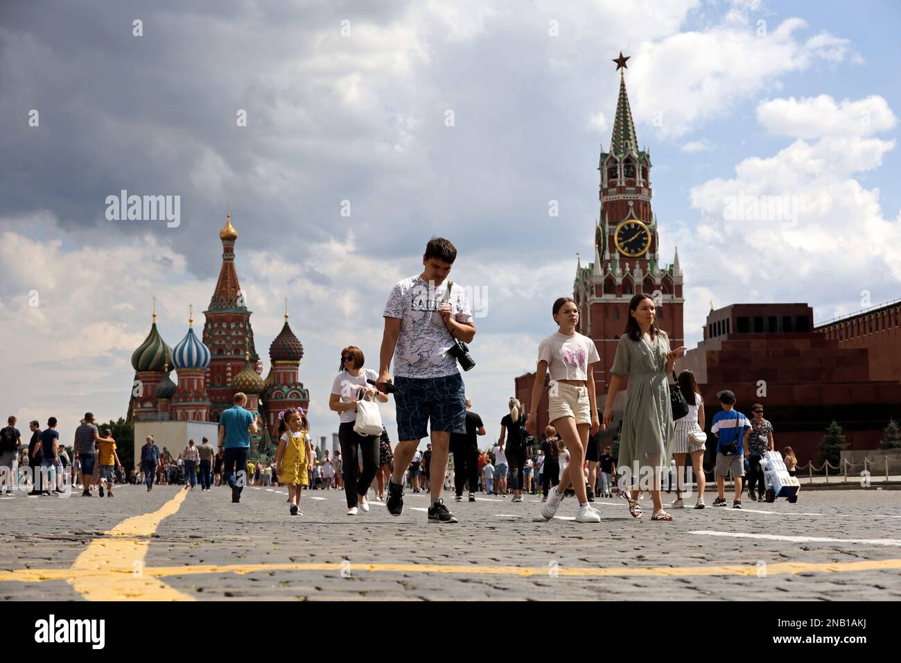 Crowd of people walking on Red square in Moscow in summer. View to the St. Basil's Cathedral and tourists Stock Photo
