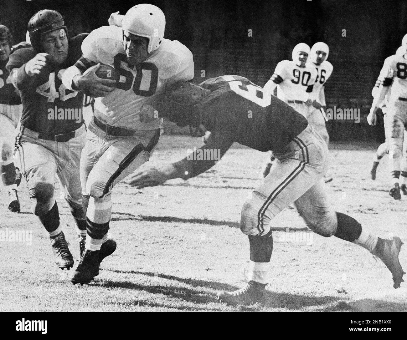 Otto Graham (60), Cleveland quarterback who led the Browns to a 34-24  victory over the Chicago Cardinals is brought down after a 7-yard gain by  Bob Dove (left) and Bill Svoboda in