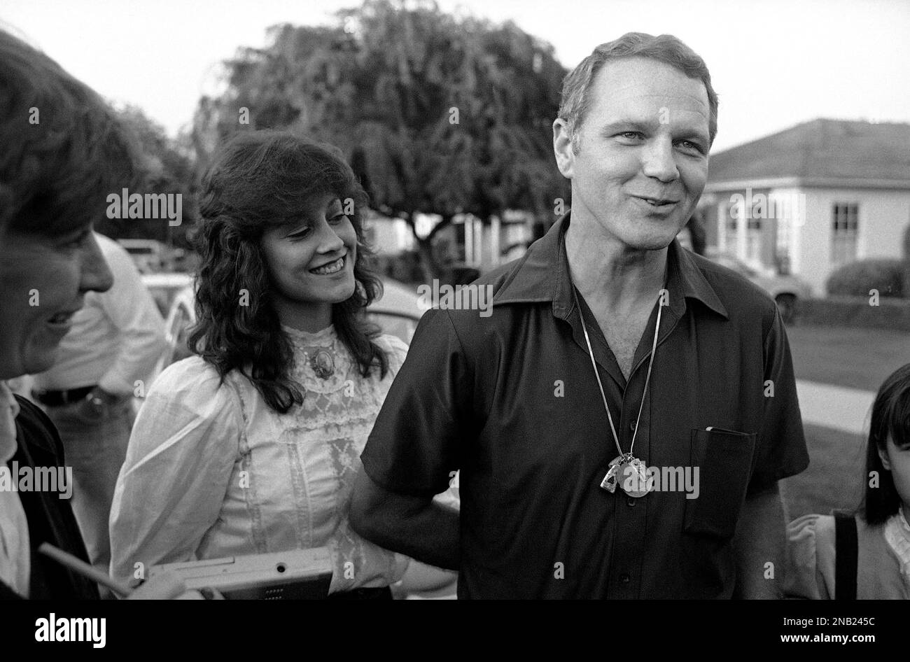 Former Green Beret officer James “Bo” Gritz smiles while talking to  reporters on the front lawn of his Westchester, California home on March  12, 1983, as wife Claudia stands beside him. Gritz