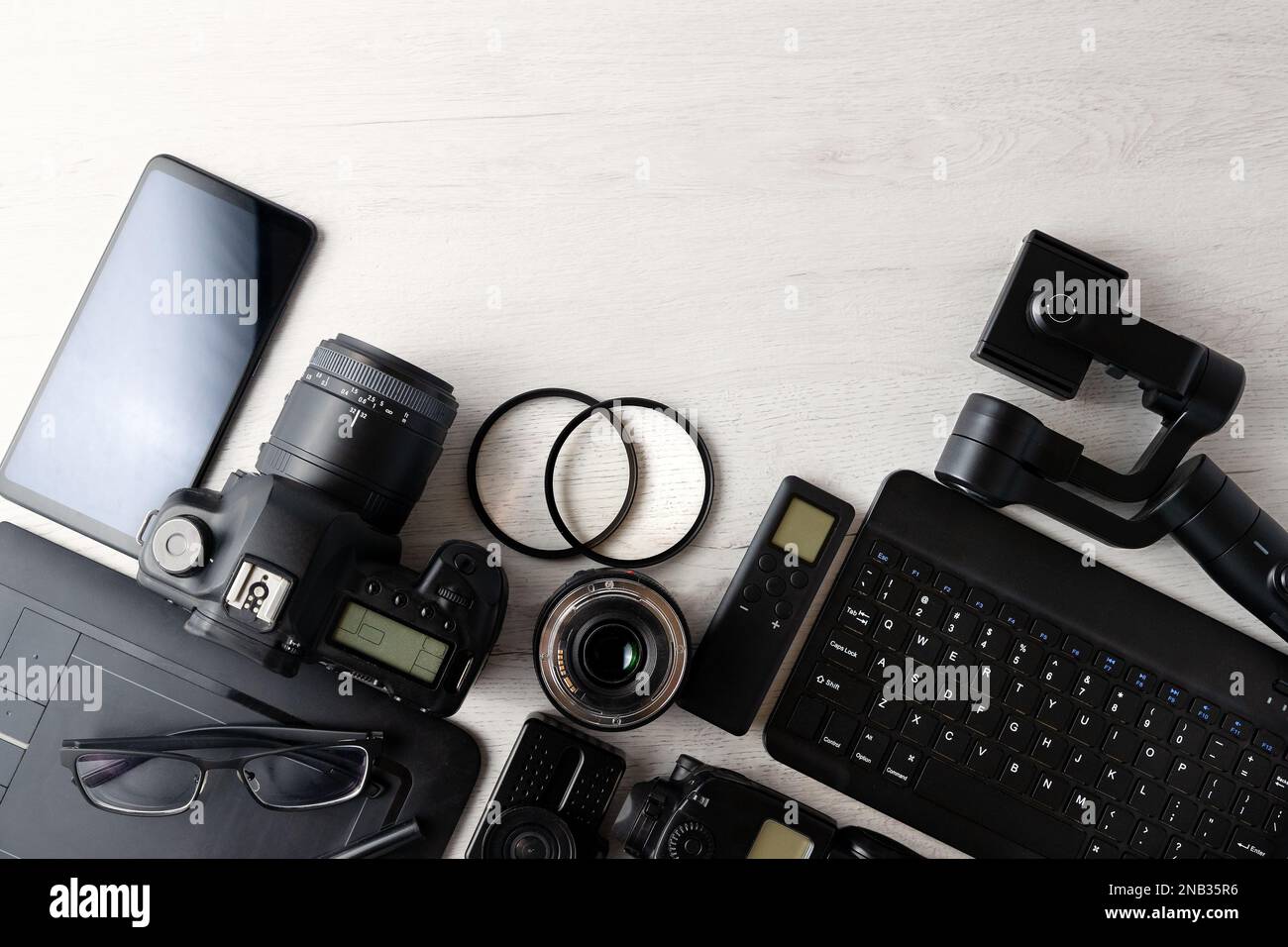 Digital photo workstation over white background.Top view of  digital camera, flash,lens and laptop.Digital photo edit and retouching. Stock Photo