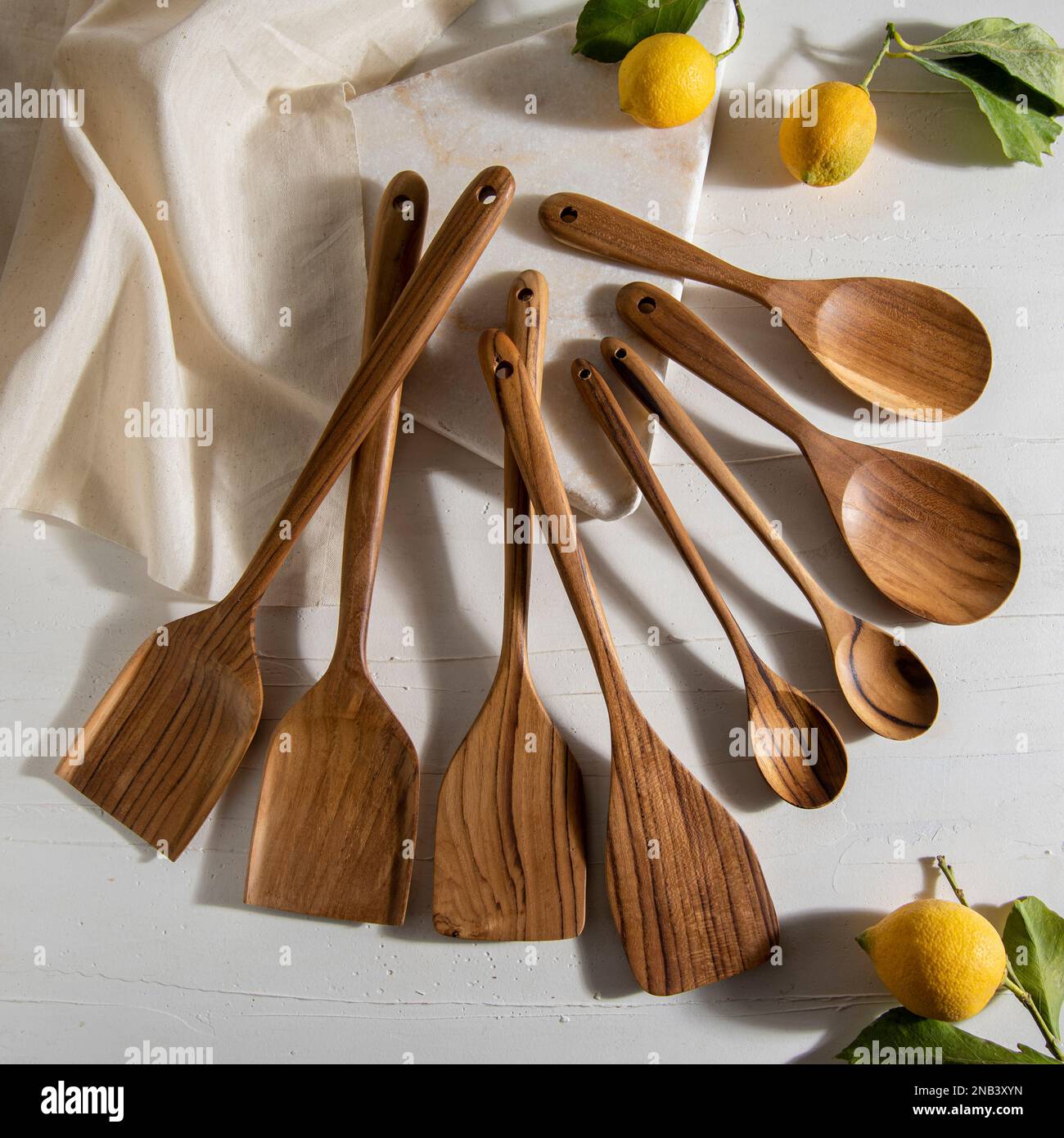 wooden kitchen tools with lemons on white marble Stock Photo