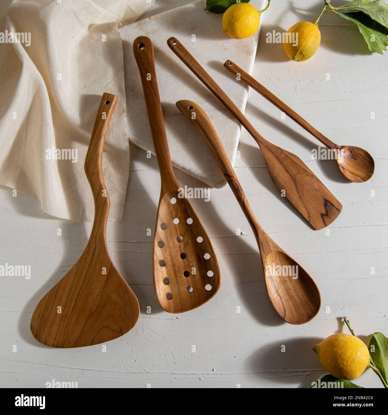 wooden kitchen tools with lemons on white marble Stock Photo