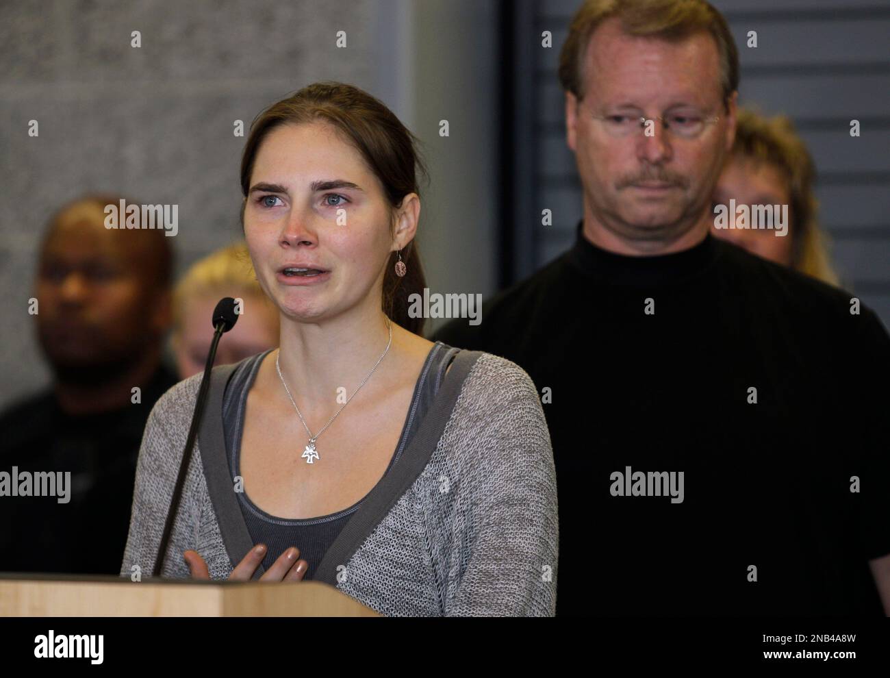 Amanda Knox talks to reporters as her father, Curt Knox, right, stands