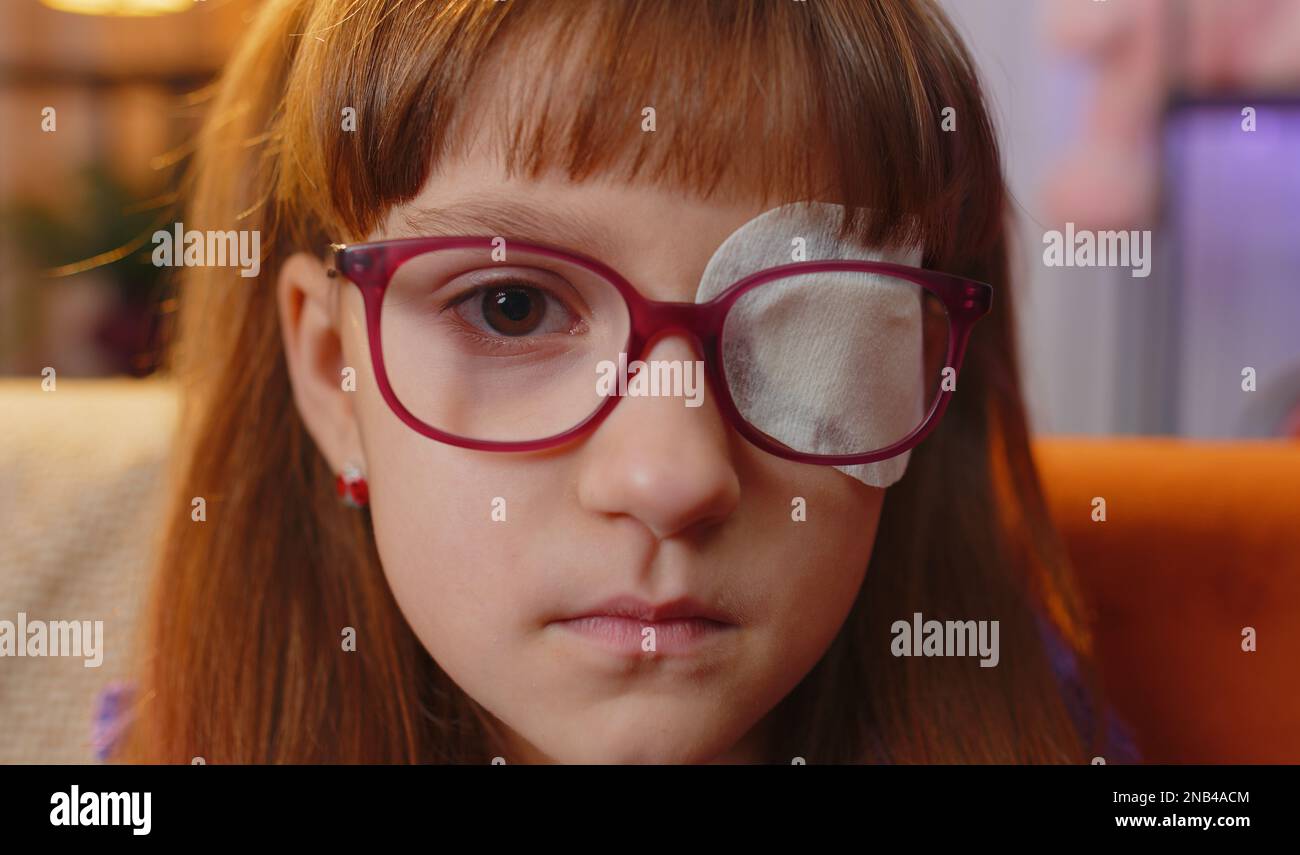 Sick ill toddler girl face looking at camera having protective bandage