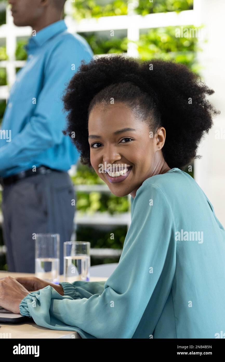 Portrait of happy african american businesswoman with laptop and ...