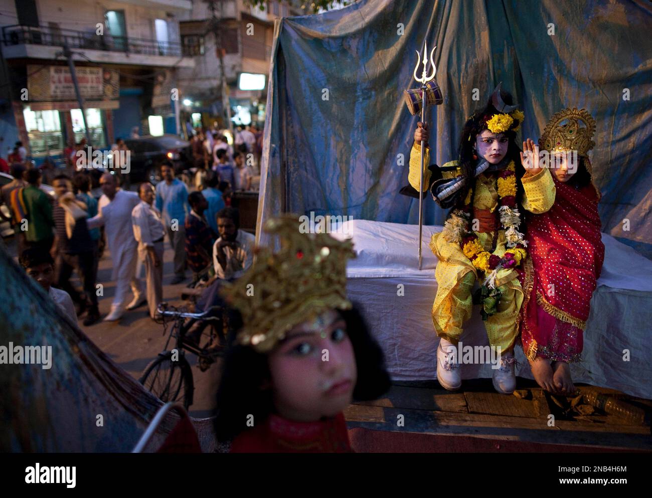 Indian children dressed as Hindu gods ride on a cart during a ...