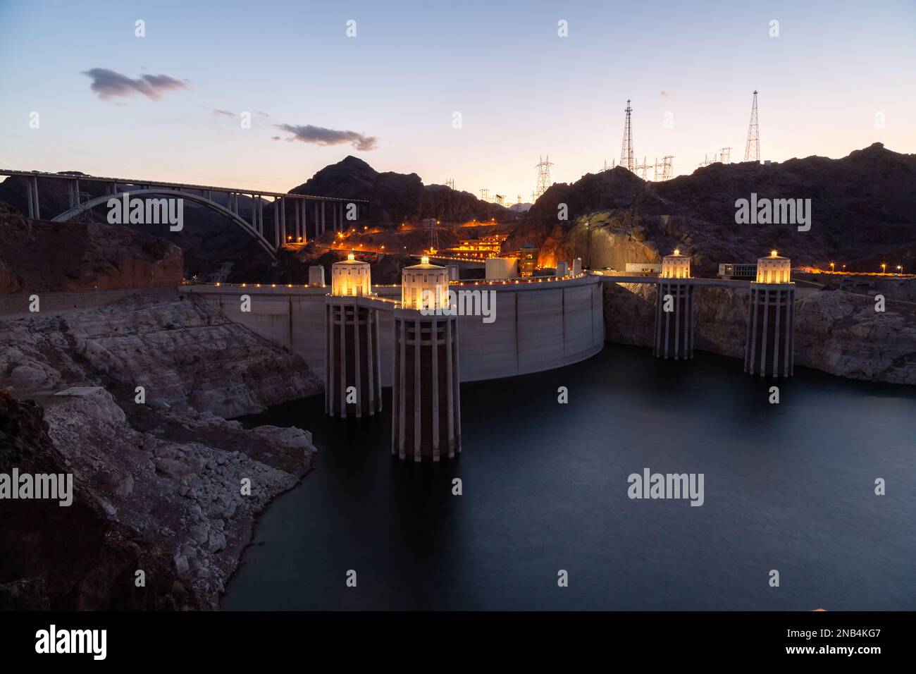 Hoover Dam at sunset in the evening with illuminations without people. Hoover dam, view point. Hoover dam and Lake Mead in Las Vegas area. Large Comstock Intake Towers At Hoover Dam. Stock Photo