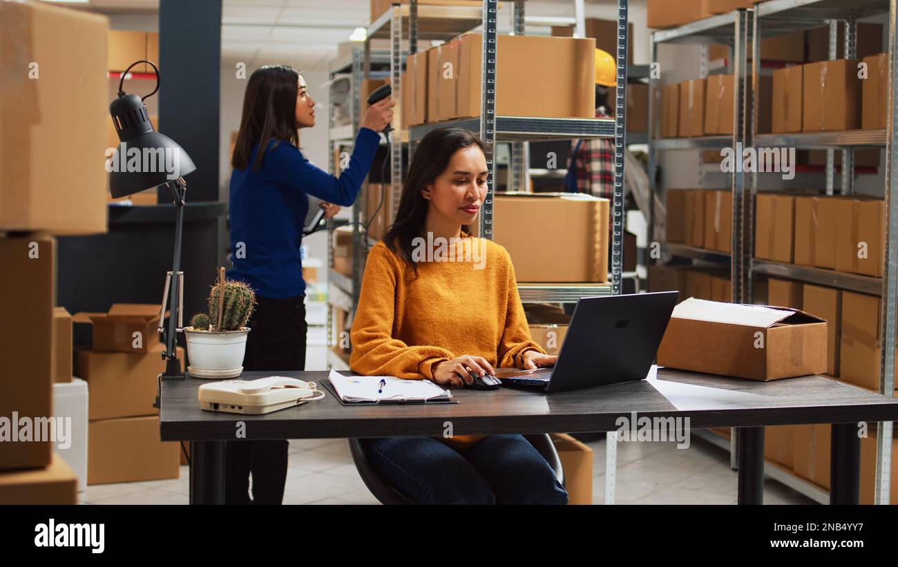 Woman employee analyzing products from racks and shelves, looking at ...