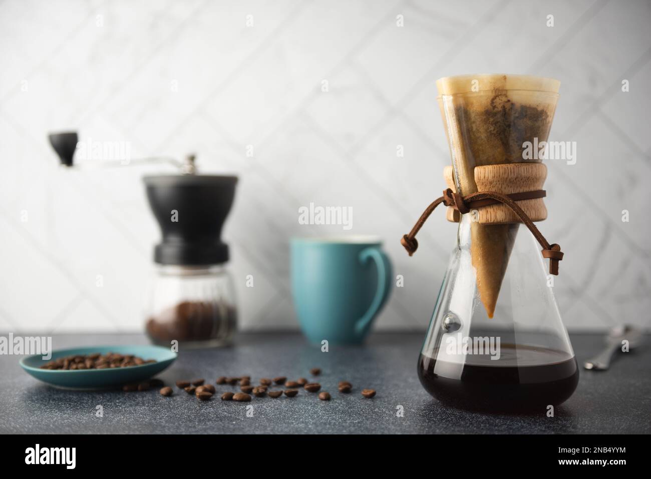 Preparing Pour-Over coffee in glass container on clean stone countertop with white marble backsplash Stock Photo