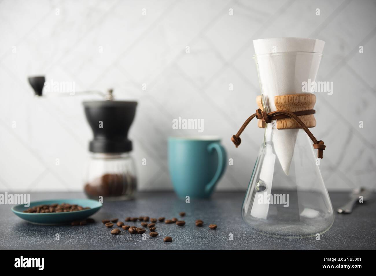 Preparing PourOver coffee in glass container on clean stone countertop