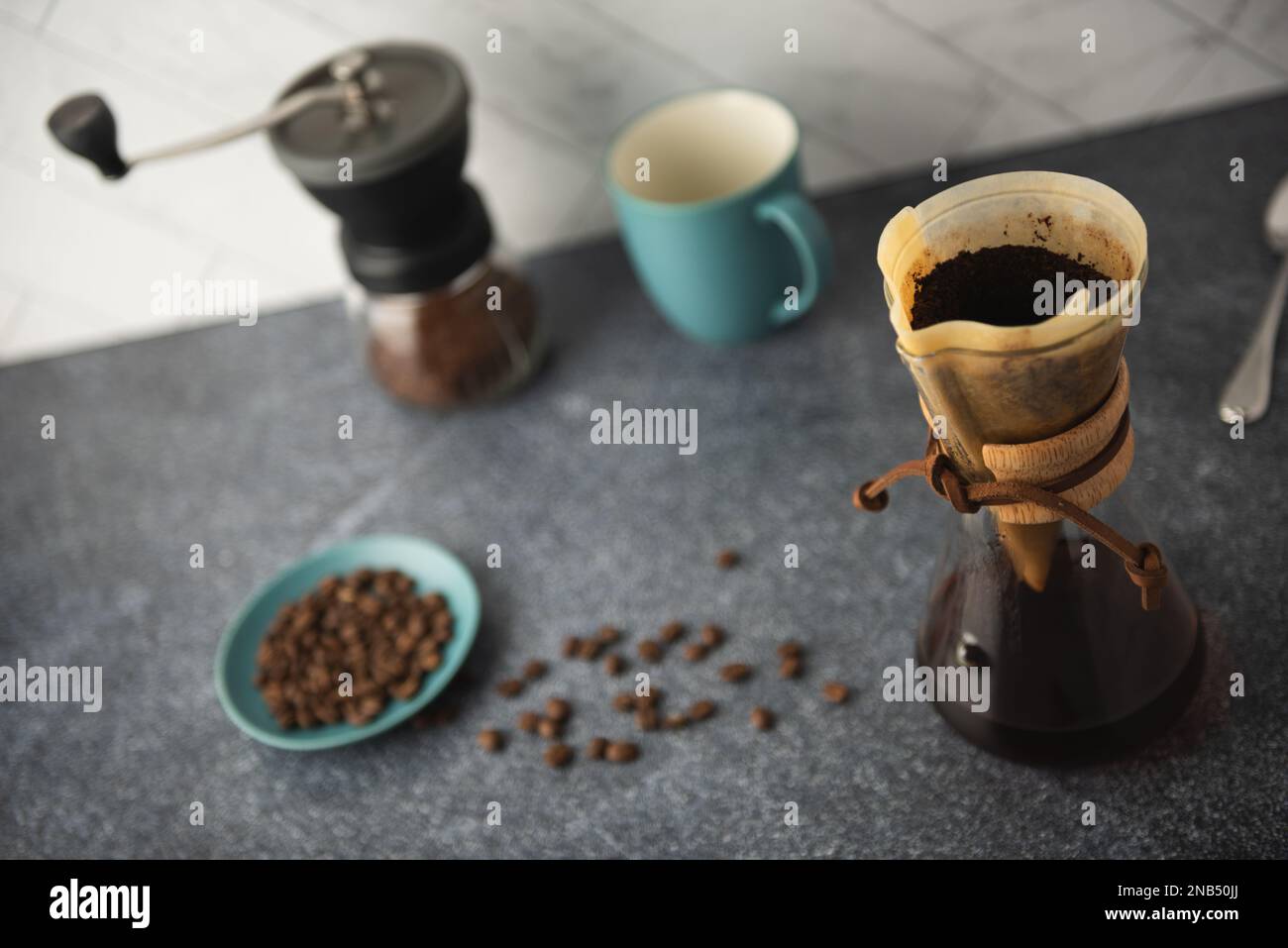 Preparing Pour-Over coffee in glass container on clean stone countertop with white marble backsplash Stock Photo