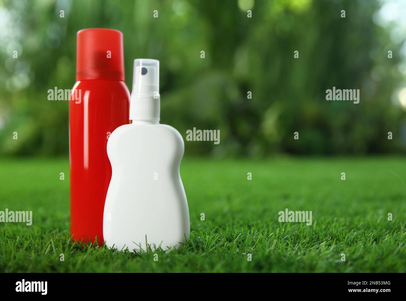 Different insect repellents on green grass. Space for text Stock Photo
