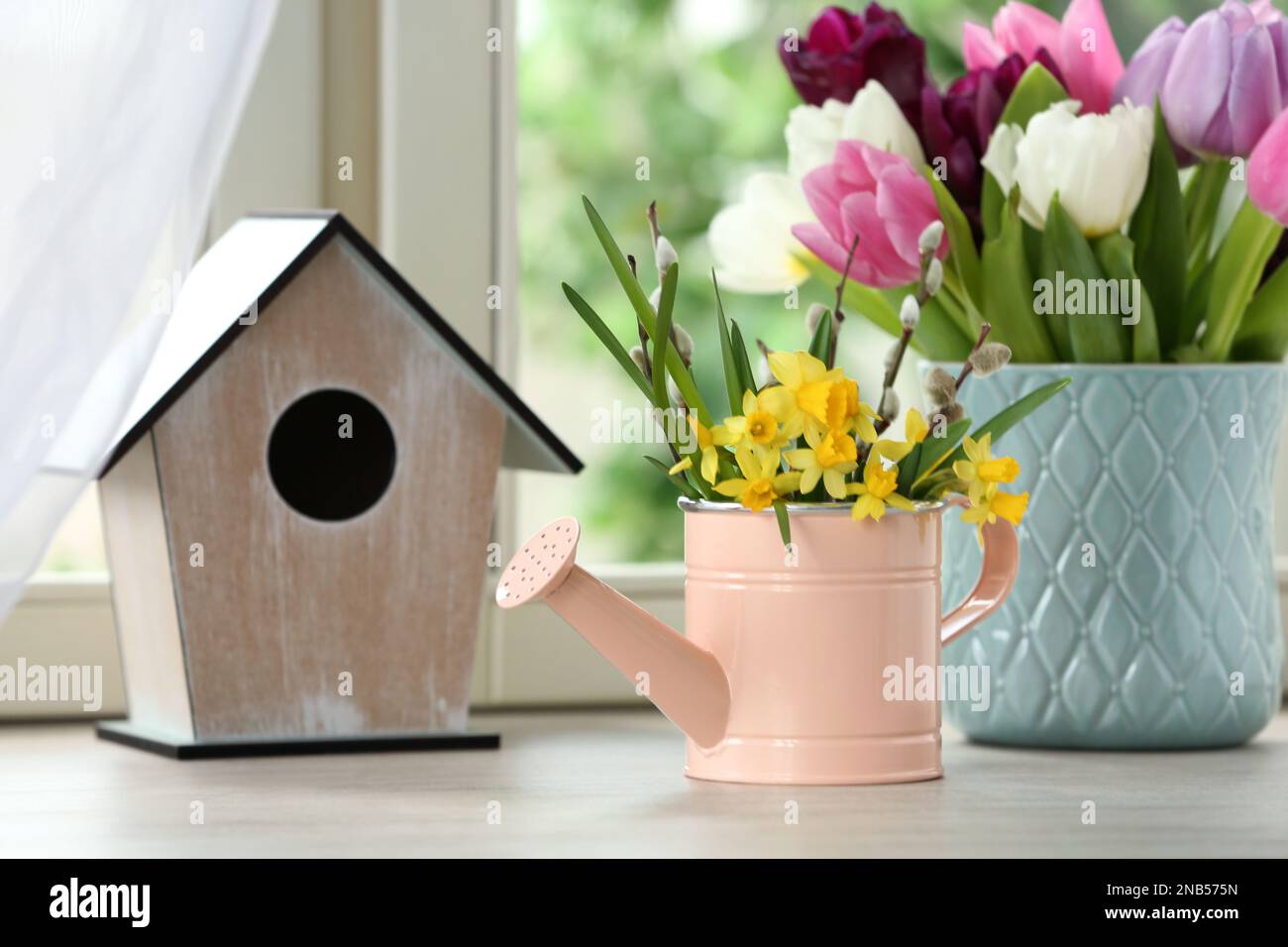 Beautiful spring flowers with birdhouse on window sill Stock Photo - Alamy