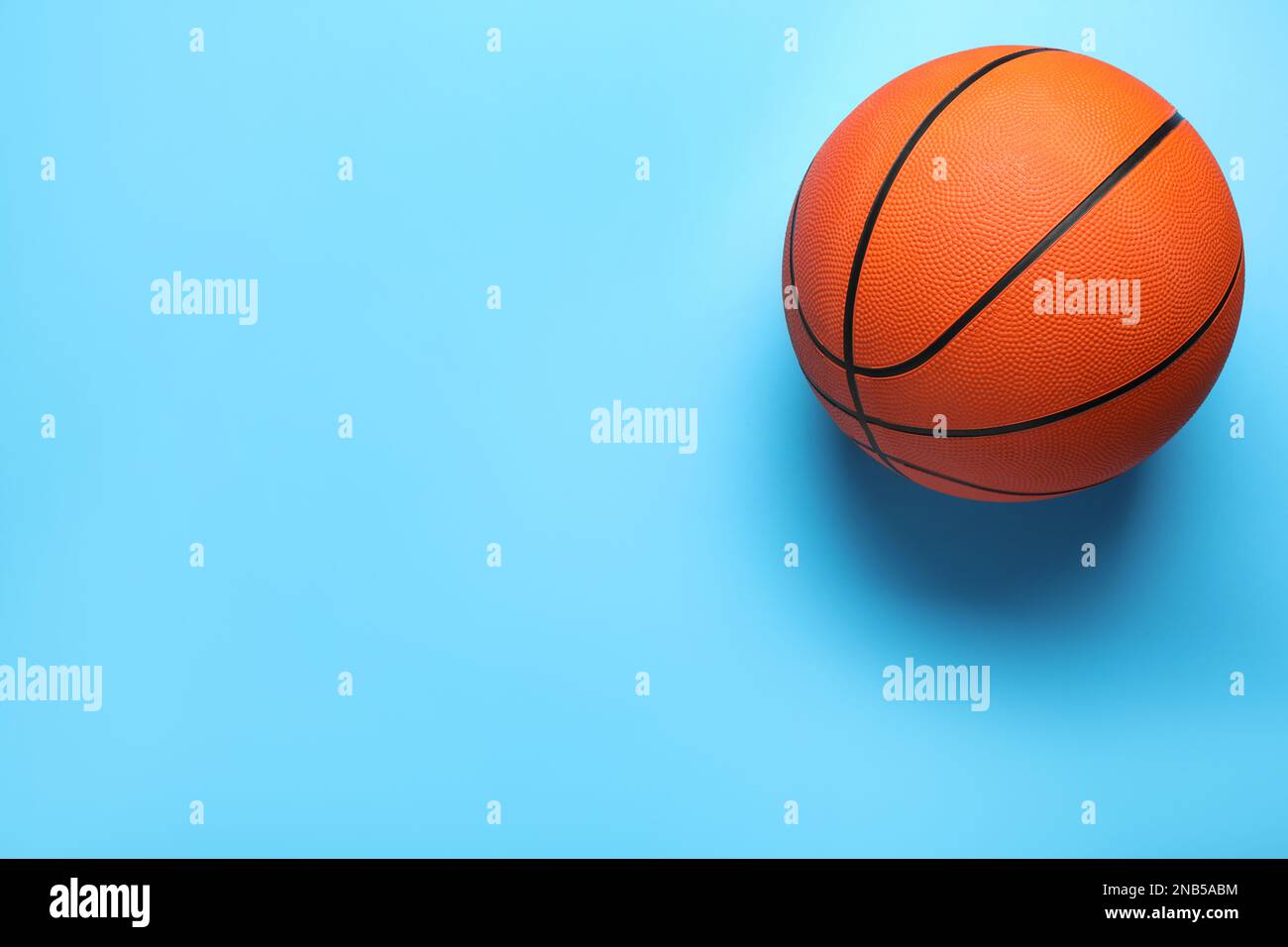 Orange ball on light blue background, top view with space for text
