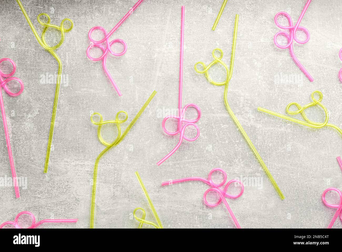 Colorful plastic drinking straws on grey stone table, flat lay Stock Photo