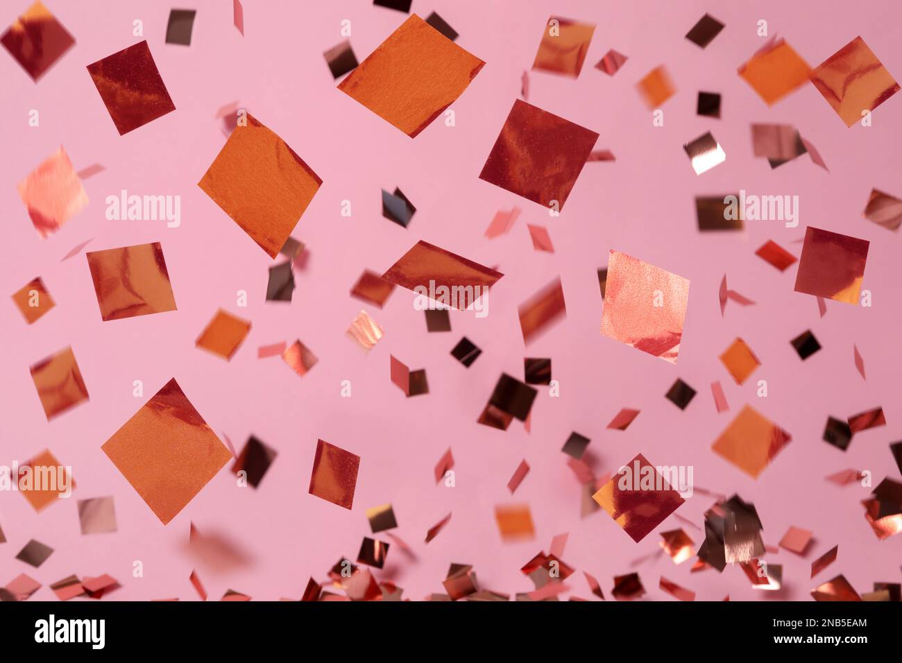 Shiny confetti falling down on pink background Stock Photo Alamy