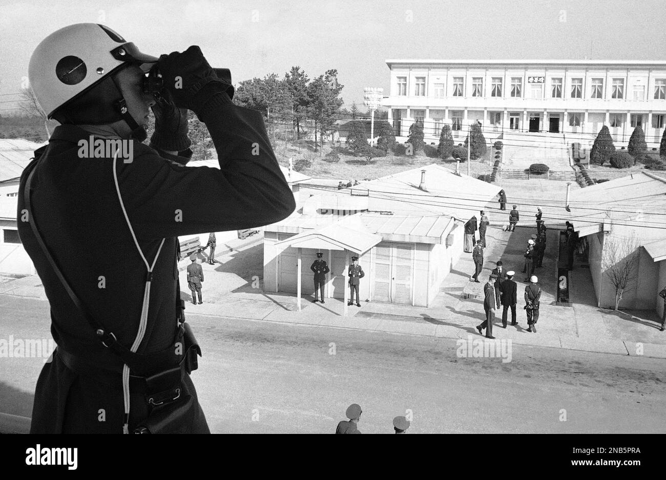 A military policeman of the United Nations command uses binoculars to ...