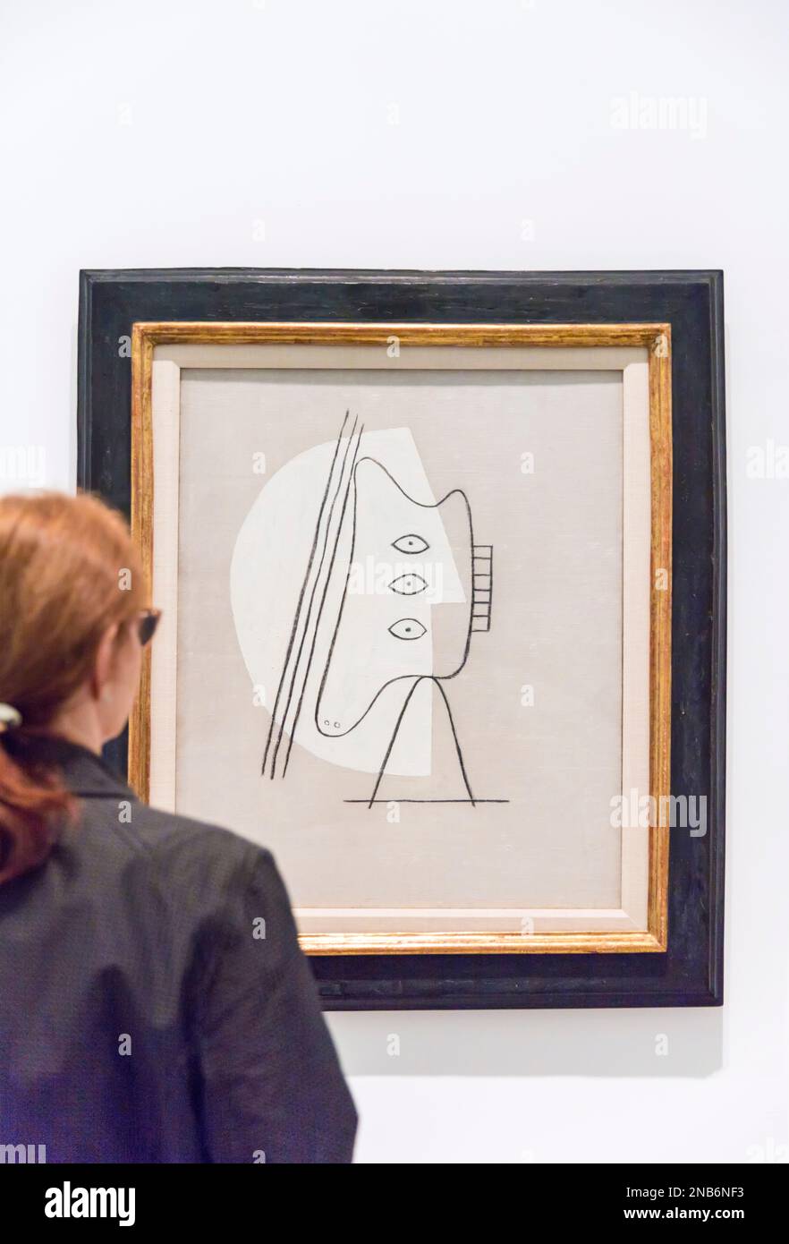 A woman looks at a Pablo Picasso painting entitled Figure (1928) in the Reina Sofia Museum in Madrid, Spain with copy space Stock Photo