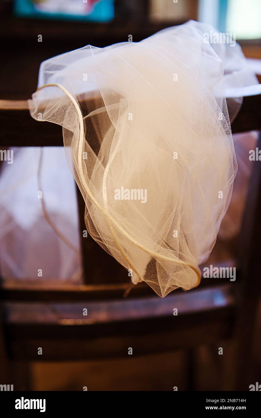 Detail of a vintage wedding dress draped over a chair Stock Photo