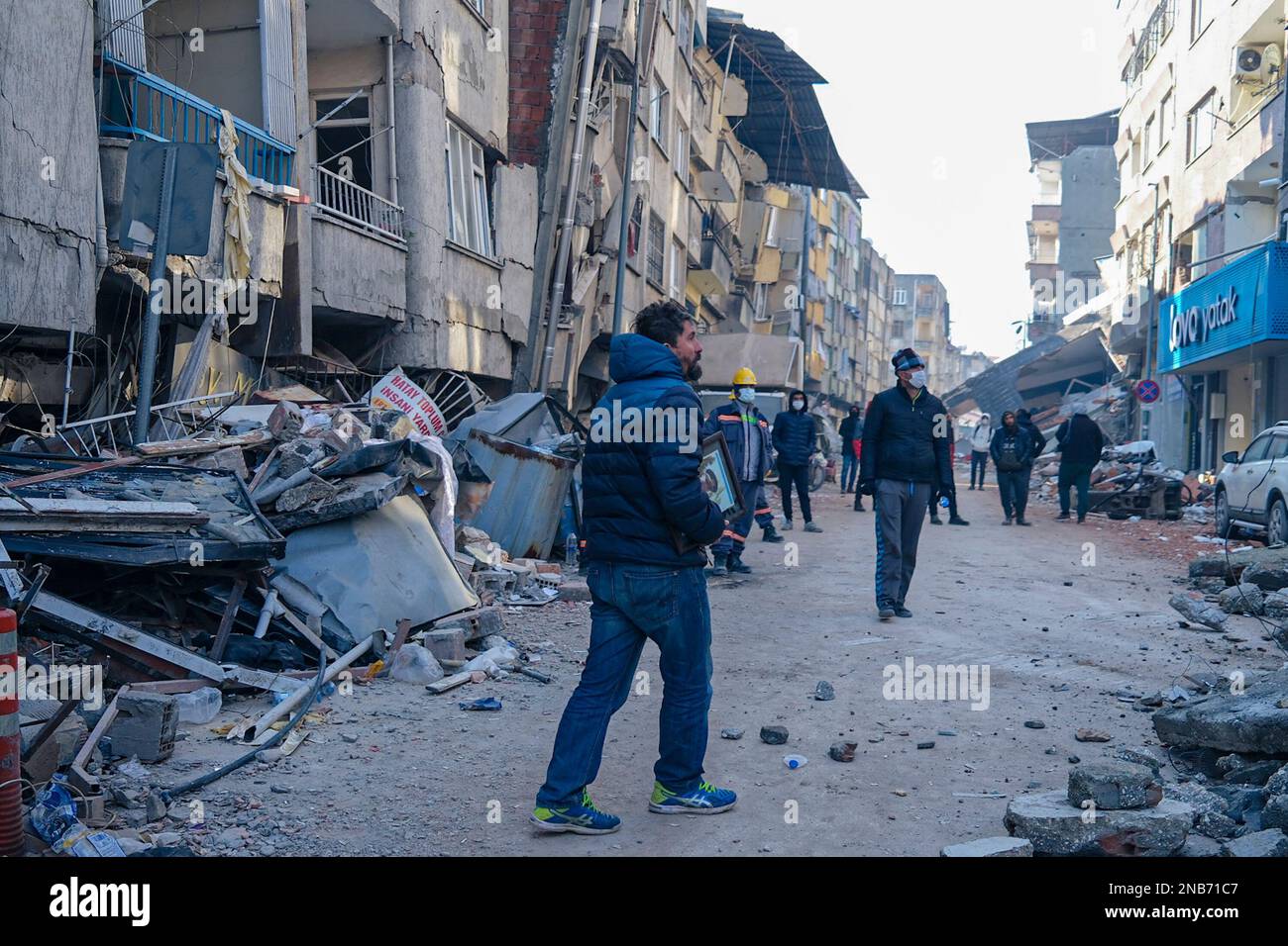 Hatay, Turkey. 13th Feb, 2023. A man is seen carrying a picture of his family still trapped in